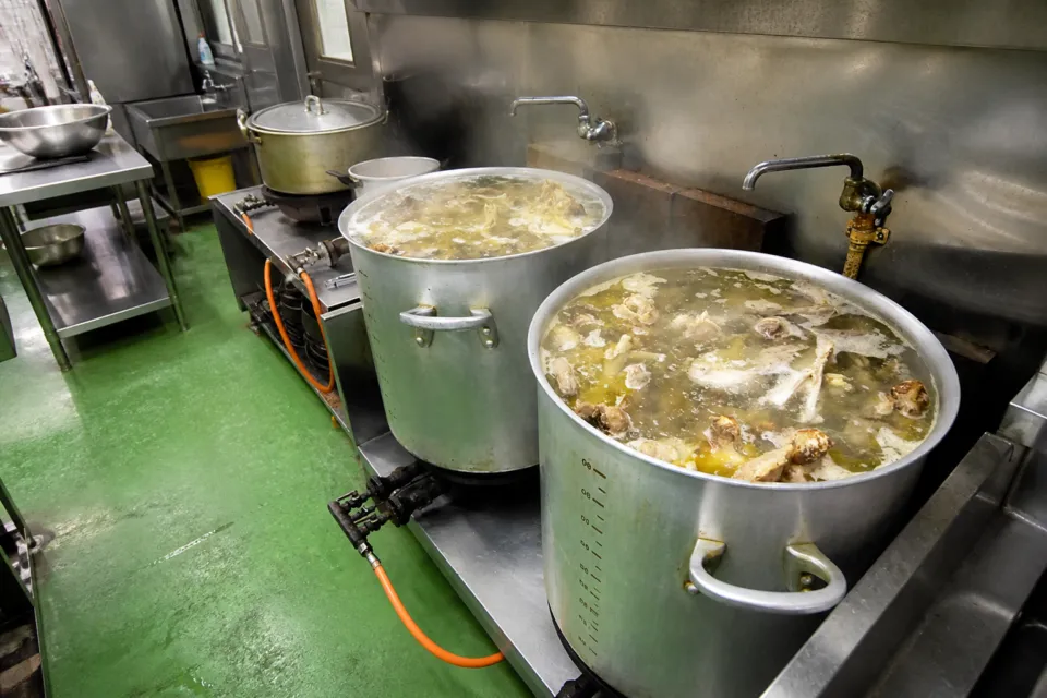 鶏飯の店 ひさ倉の厨房の大鍋で鶏だしを煮出している仕込み風景