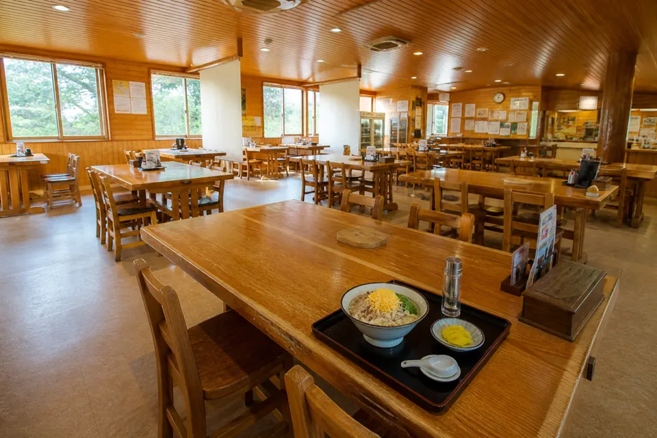 鶏飯の店 ひさ倉の木のテーブルと椅子が整然と並ぶ店内