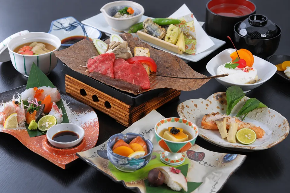 休暇村妙高の小鉢や鍋を並べた会席料理