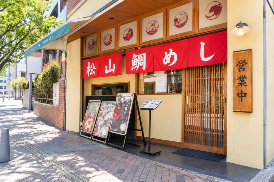 松山鯛めし 秋嘉 本店の赤い暖簾が掛かる秋嘉本店の入口