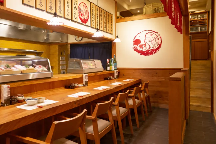 松山鯛めし 秋嘉 本店の木のカウンターと厨房が見える店内
