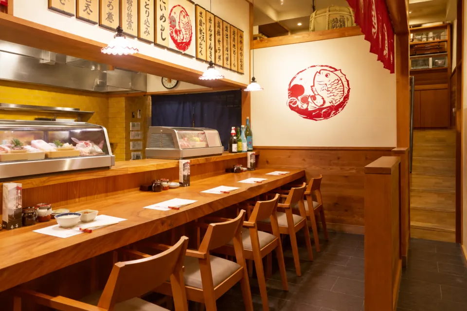 松山鯛めし 秋嘉 本店の木のカウンターと厨房が見える店内