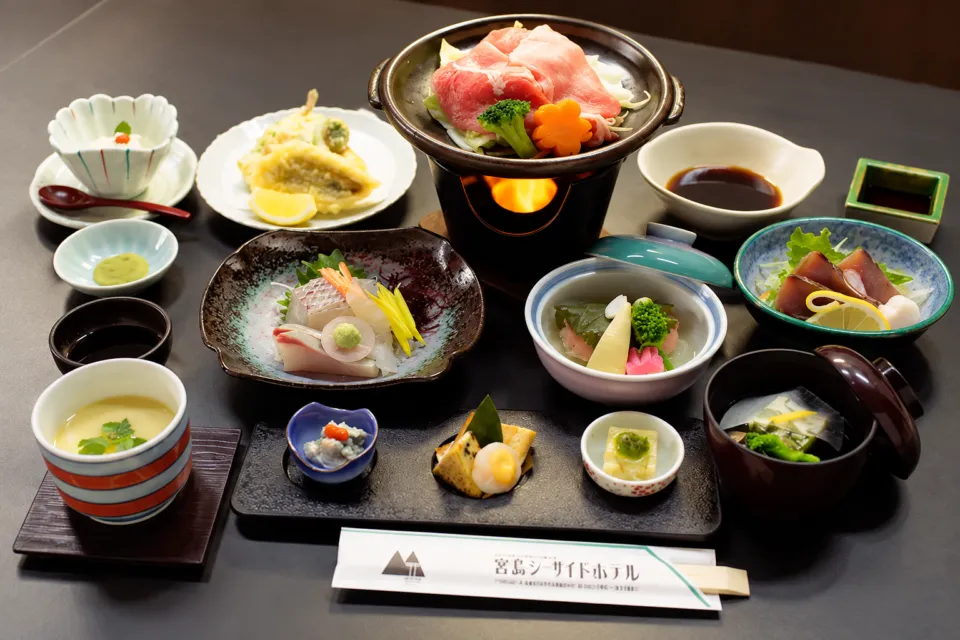 宮島シーサイドホテルの刺身や小鍋を並べた会席料理