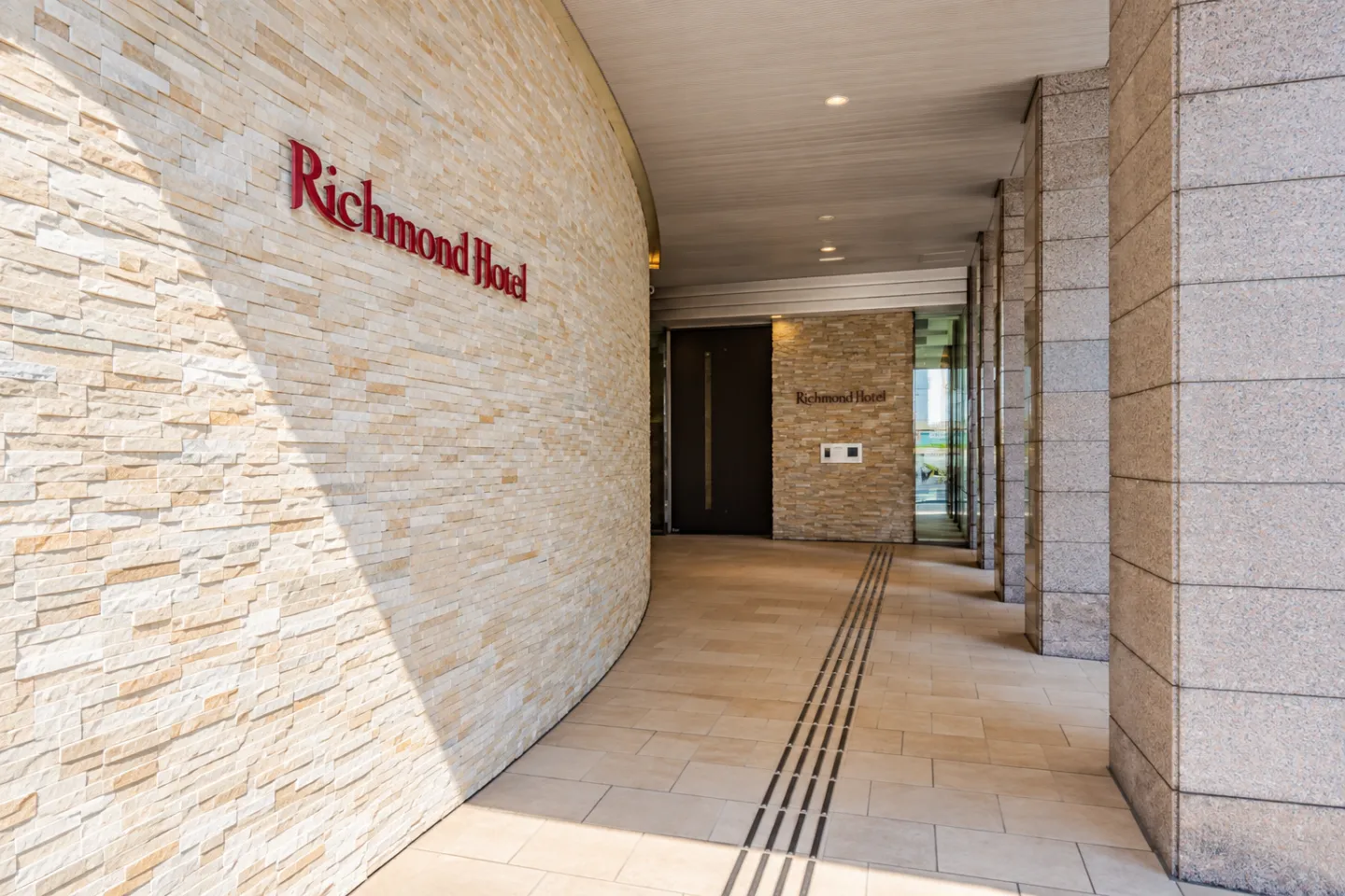 リッチモンドホテル秋田駅前の石張りの壁とホテル名の看板がある入口