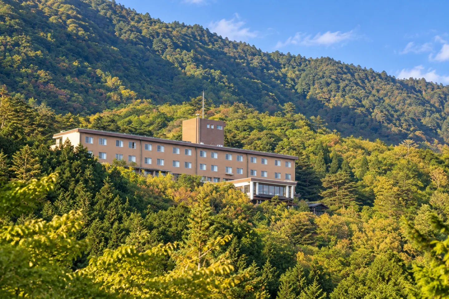 旅行人山荘の自然林に囲まれた外観