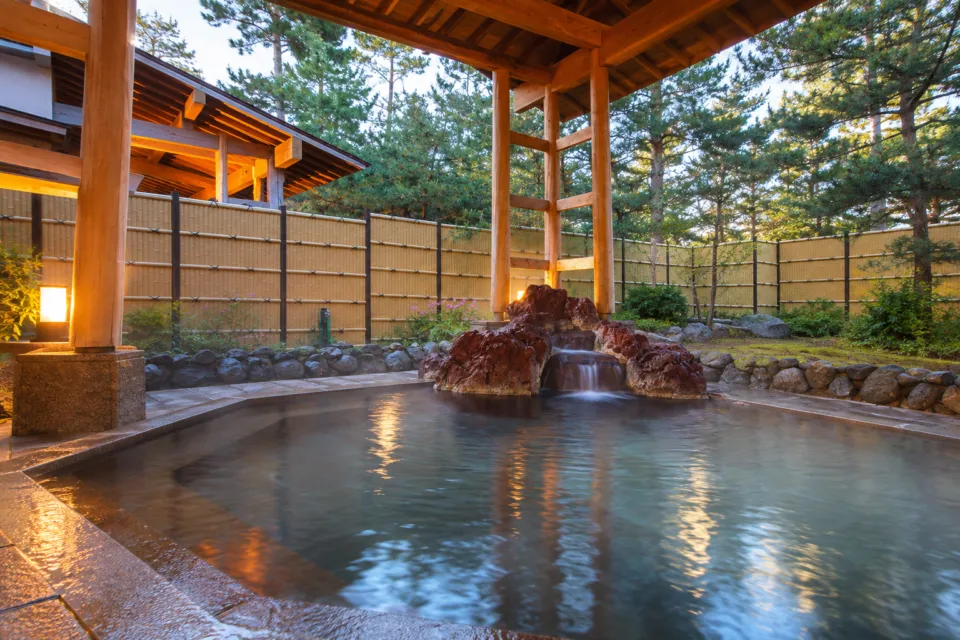 国際佐渡観光ホテル 八幡館の岩に囲まれた屋根付き露天風呂