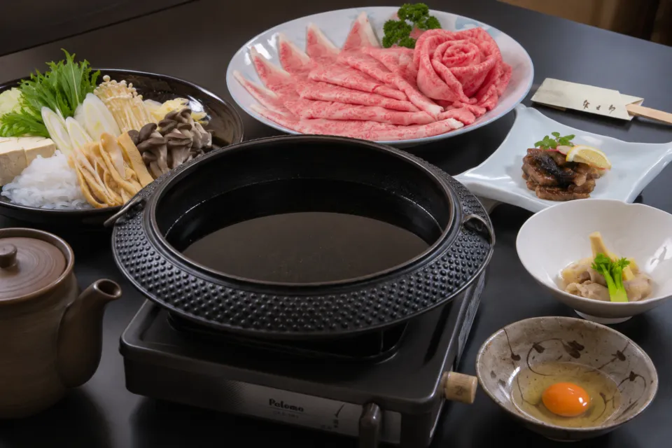 和風肉料理 佐五郎の霜降り牛肉と野菜が並ぶすき焼きコース