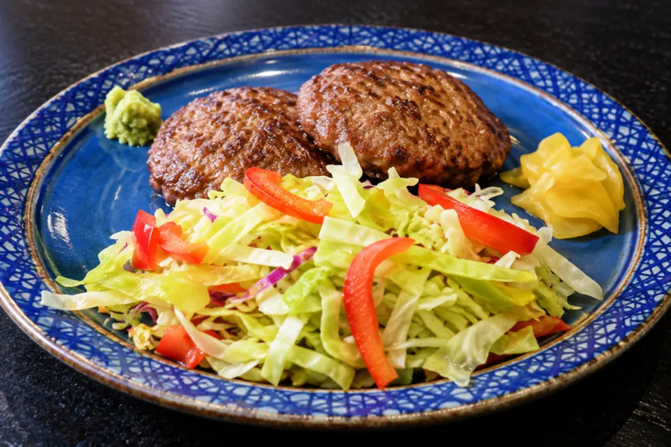 和風肉料理 佐五郎の青い皿に野菜を添えたハンバーグ