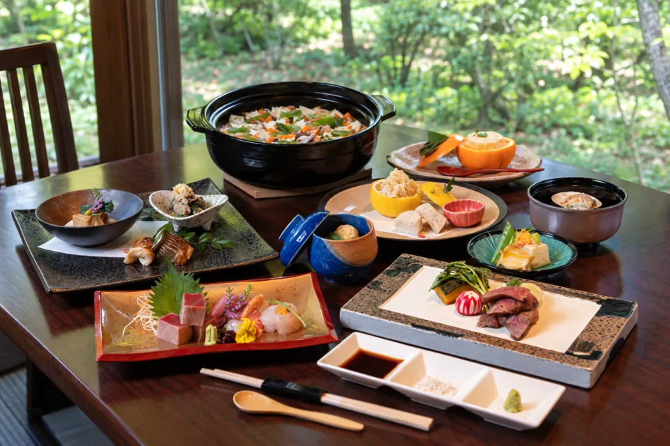 四季茶房八夢の庭園を背景に並ぶ会席料理