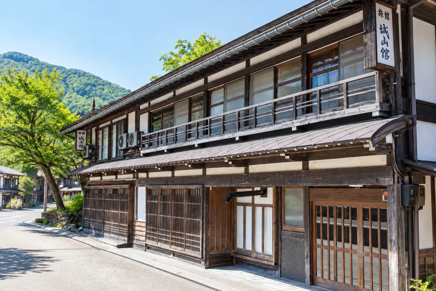 城山館の格子戸と二階の木造窓が連なる建物正面