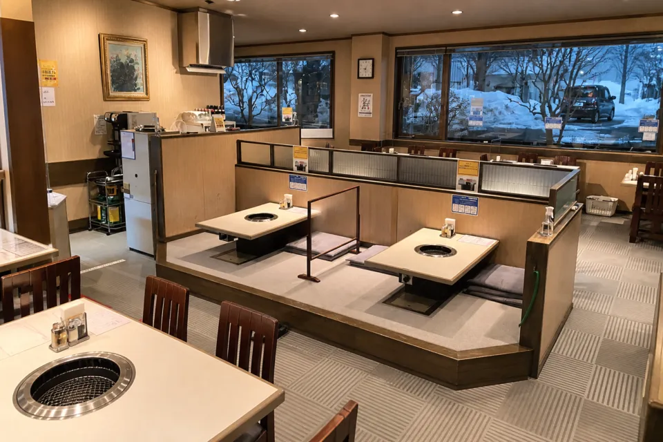 食道園の焼肉卓と座敷が見える店内