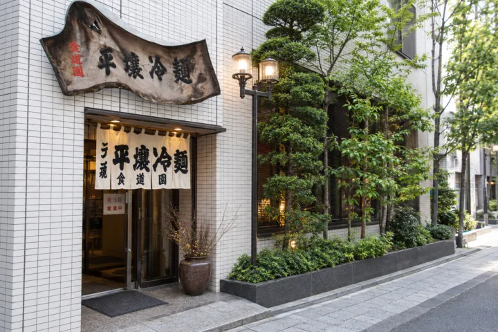 食道園の白い外壁と暖簾のある店舗外観
