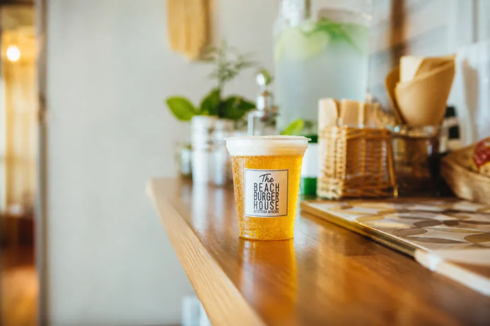 The BEACH BURGER HOUSEの店名ロゴ入りカップのクラフトビール