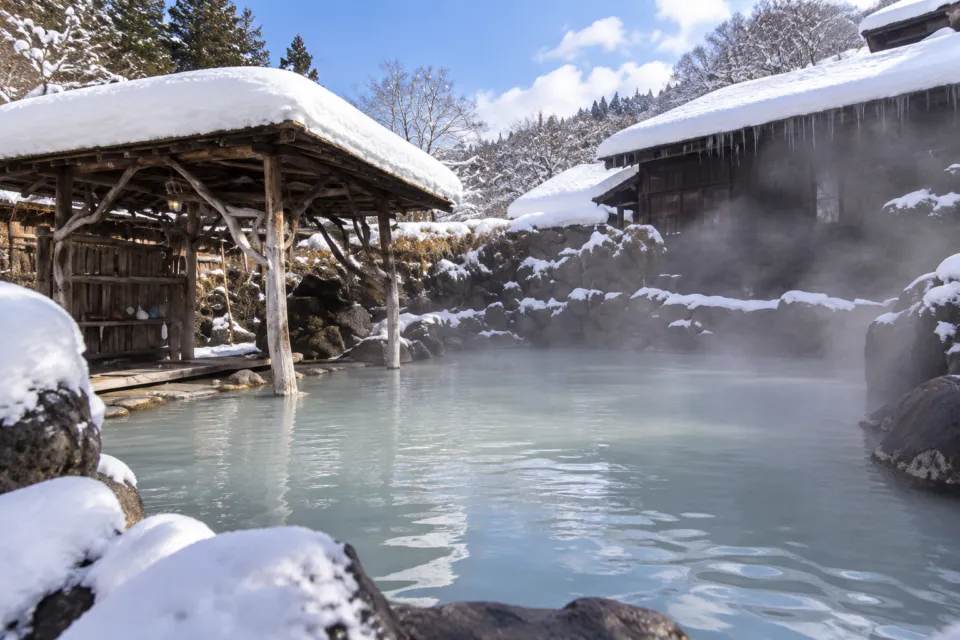 鶴の湯温泉の雪をかぶった湯小屋と露天風呂