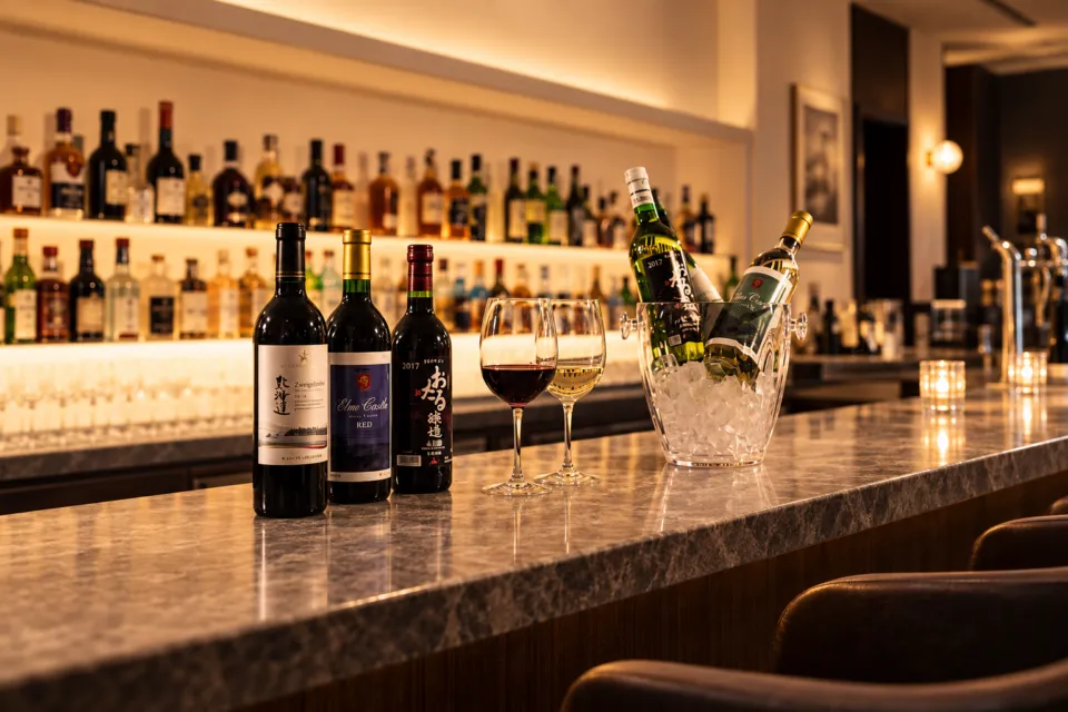 UNWIND HOTEL & BAR 小樽のカウンターに並ぶワインとグラス