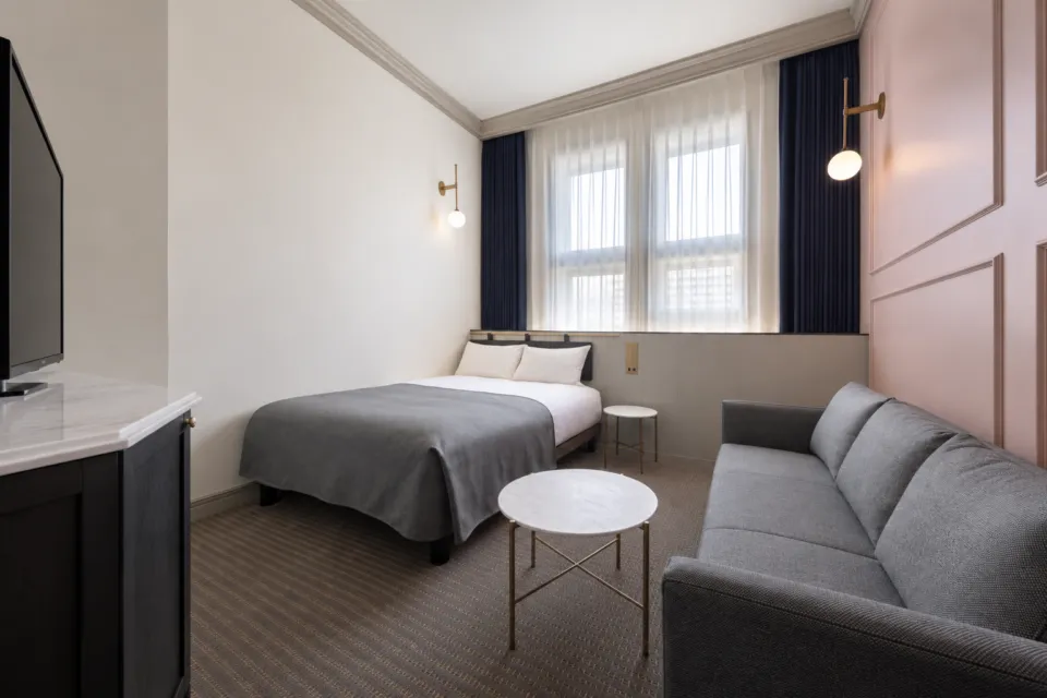 UNWIND HOTEL & BAR 小樽のダブルベッドと窓側のソファ