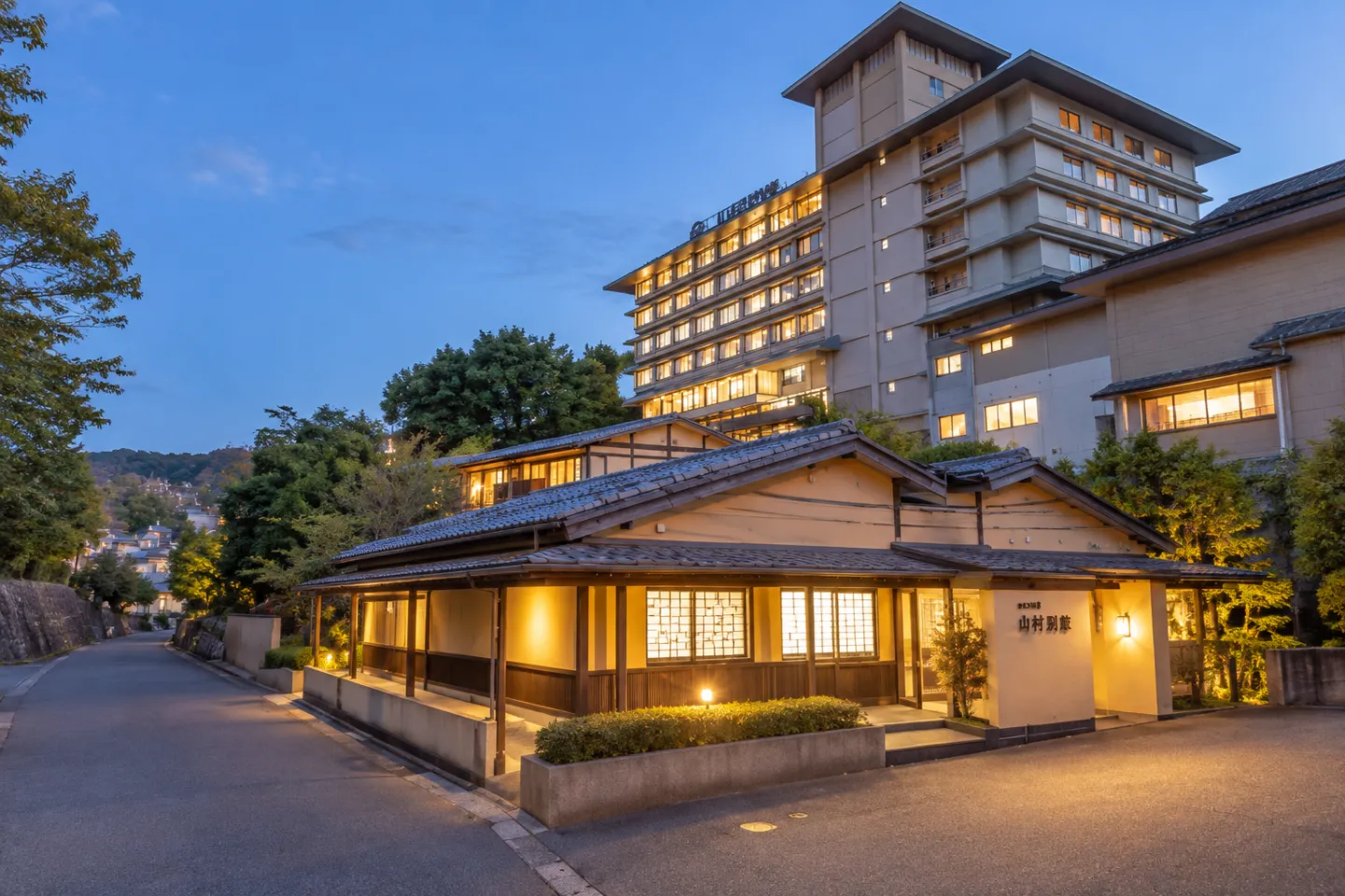 山村別館の夕暮れに明かりがともる外観