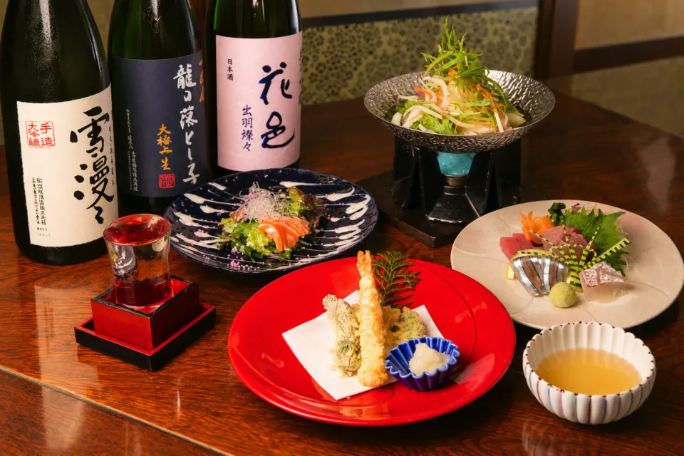 座・寿鈴の天ぷらや魚料理と日本酒を並べた食卓