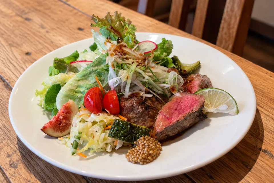 Bakery Restaurant CURRENTの肉料理と野菜を盛り付けたプレート