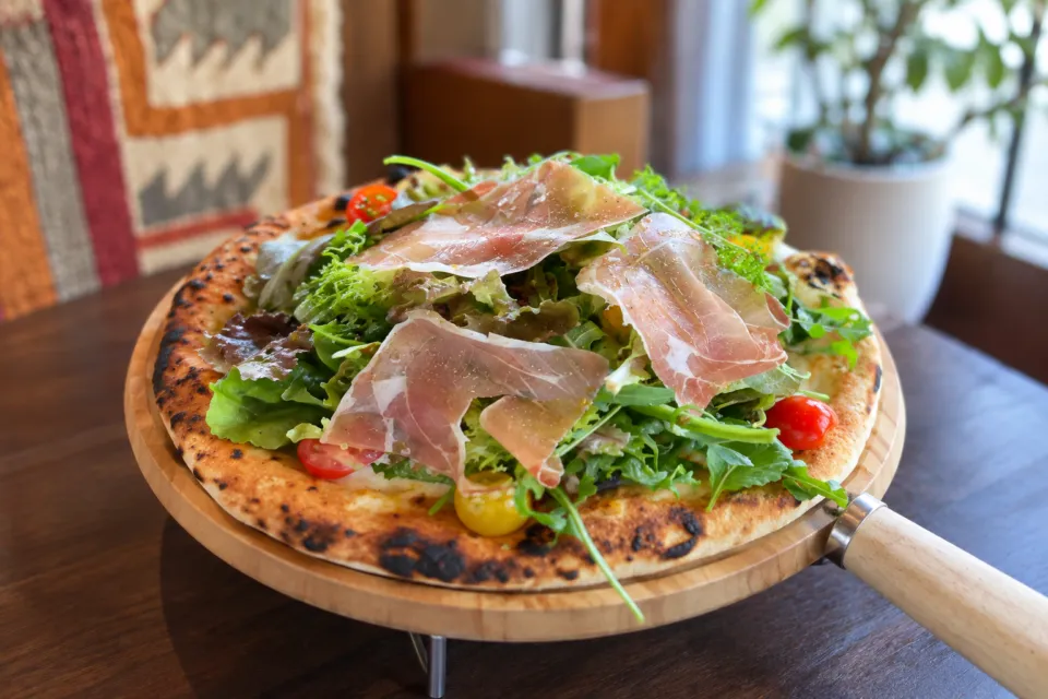 Bakery Restaurant CURRENTの生ハムと葉野菜をのせたピザ