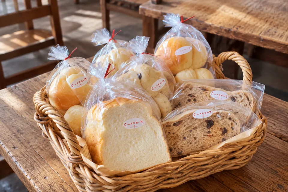 Bakery Restaurant CURRENTのかごに並ぶ持ち帰り用のパン