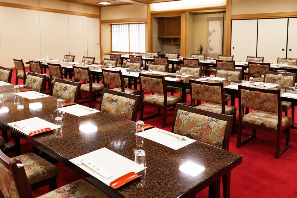 博多料亭 稚加榮 福岡店の宴会場の椅子とテーブル席