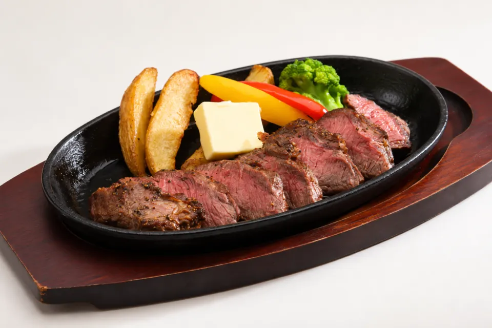 エンヤサンゴ 皆生ホテル店の鉄板の肉料理と付け合わせ