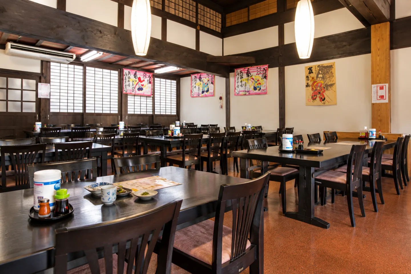 五箇山の味 ふるさとの木の梁とテーブル席が並ぶ店内