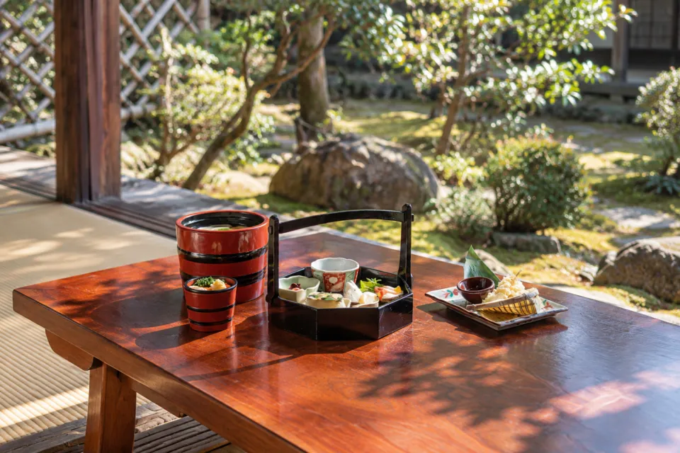 郷屋敷 本店の庭を望む卓上に並ぶ和食とうどん