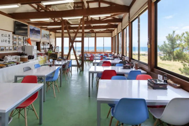 漁港食堂だいぼの海が見える店内と料理の並ぶ食卓