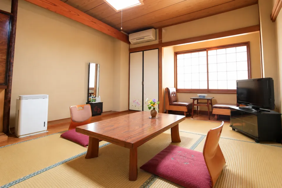 花旅館 岩戸屋の和室の座卓と窓側の椅子