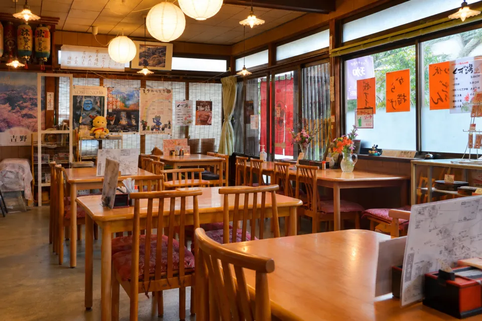 花山 山本の木製テーブルと椅子が並ぶ飲食スペース