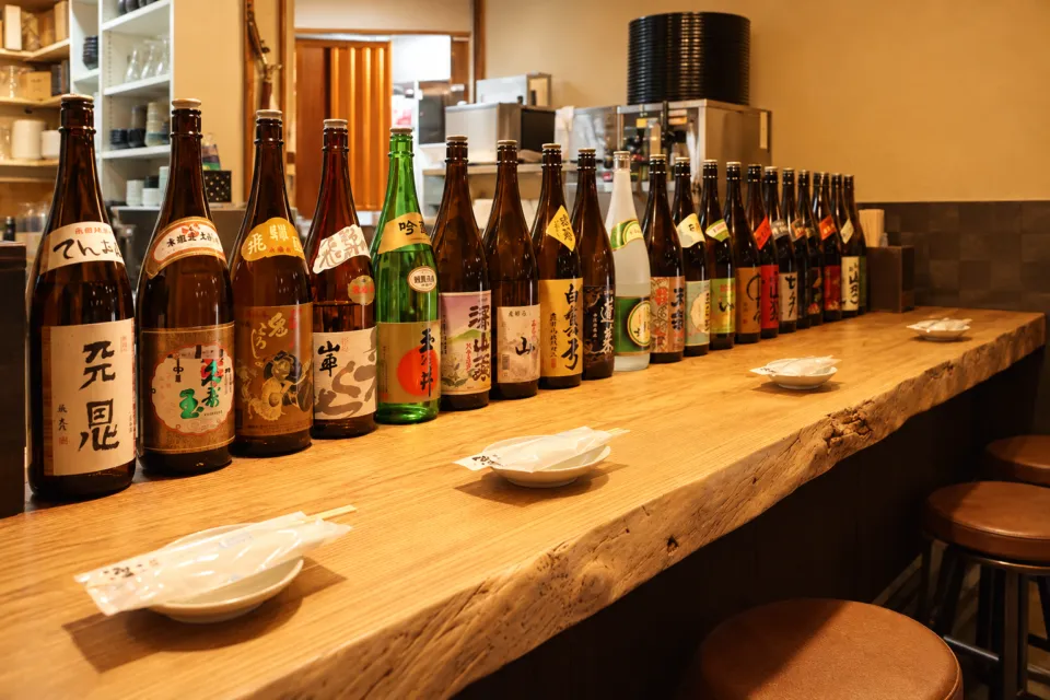 飛騨の味 酒菜の酒瓶が並ぶカウンター席