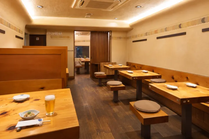 飛騨の味 酒菜の木のテーブル席と土壁の店内
