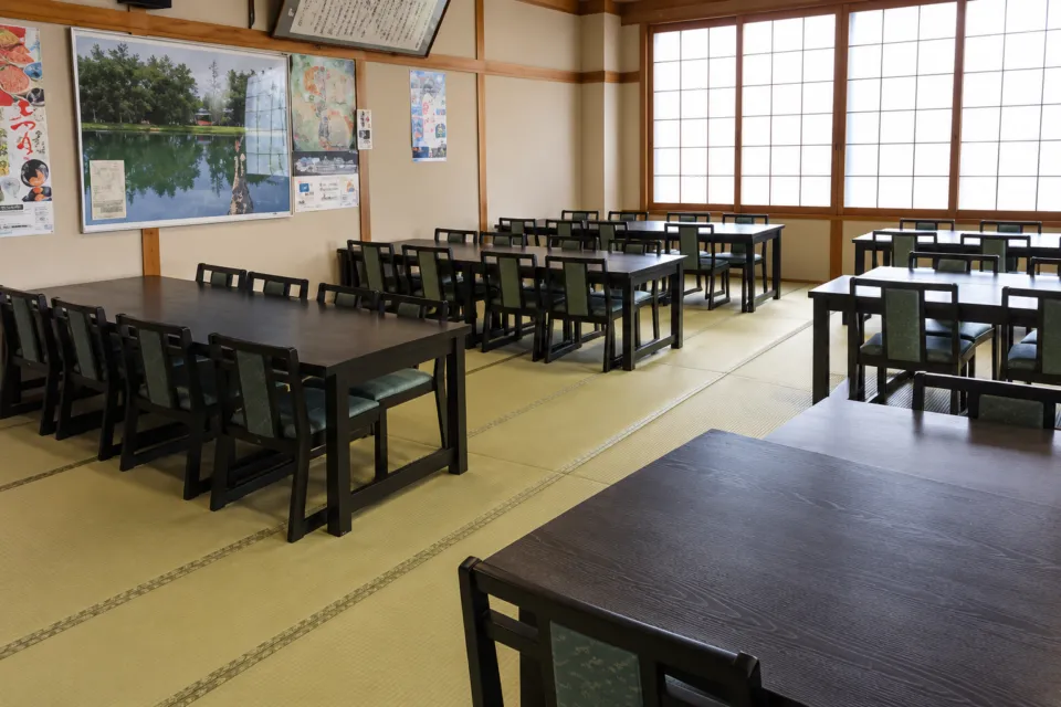 平泉レストハウスの畳敷きの団体食事会場に並ぶテーブルと椅子