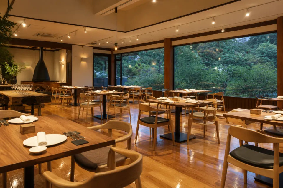 Kaji synergy restaurantの夜のテーブル席が並ぶ店内