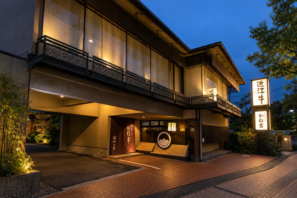 近江牛 かね吉の灯りがともる夕暮れの店舗外観