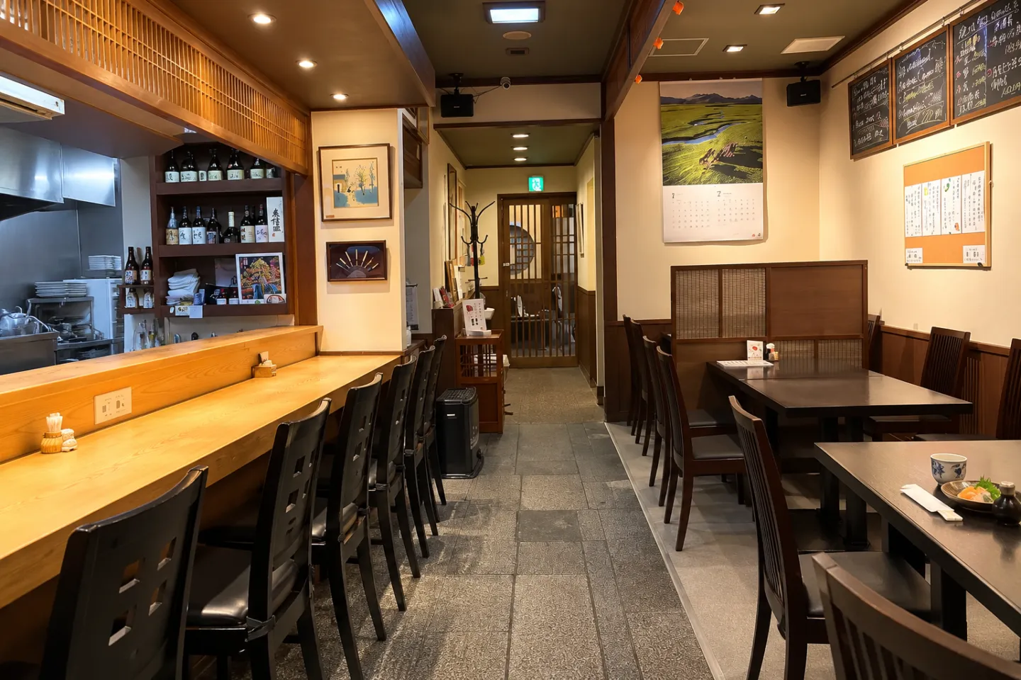割烹 千渡里の仕切りのある椅子席とカウンターが見える店内