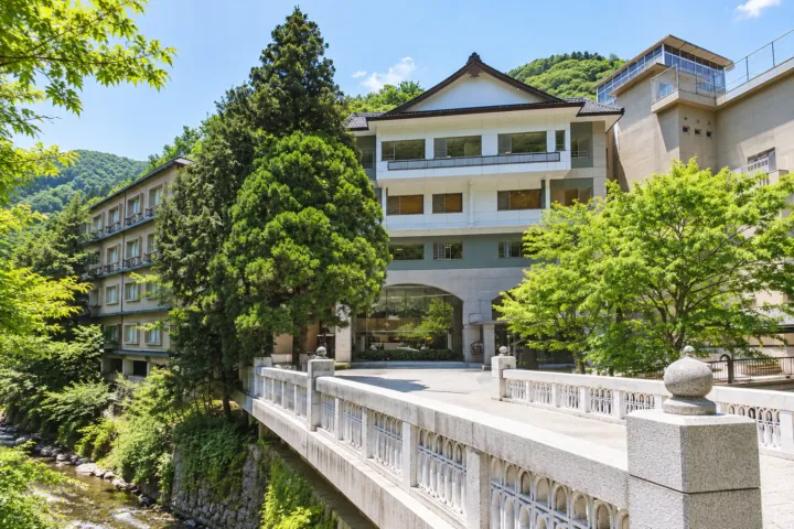 くつろぎ宿 新滝の橋の先に建つ旅館の正面外観