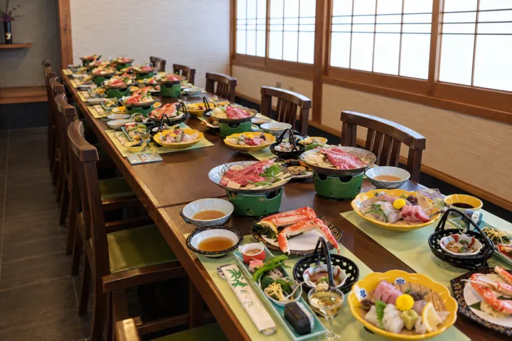 松の江の椅子席に会食の料理を並べた店内