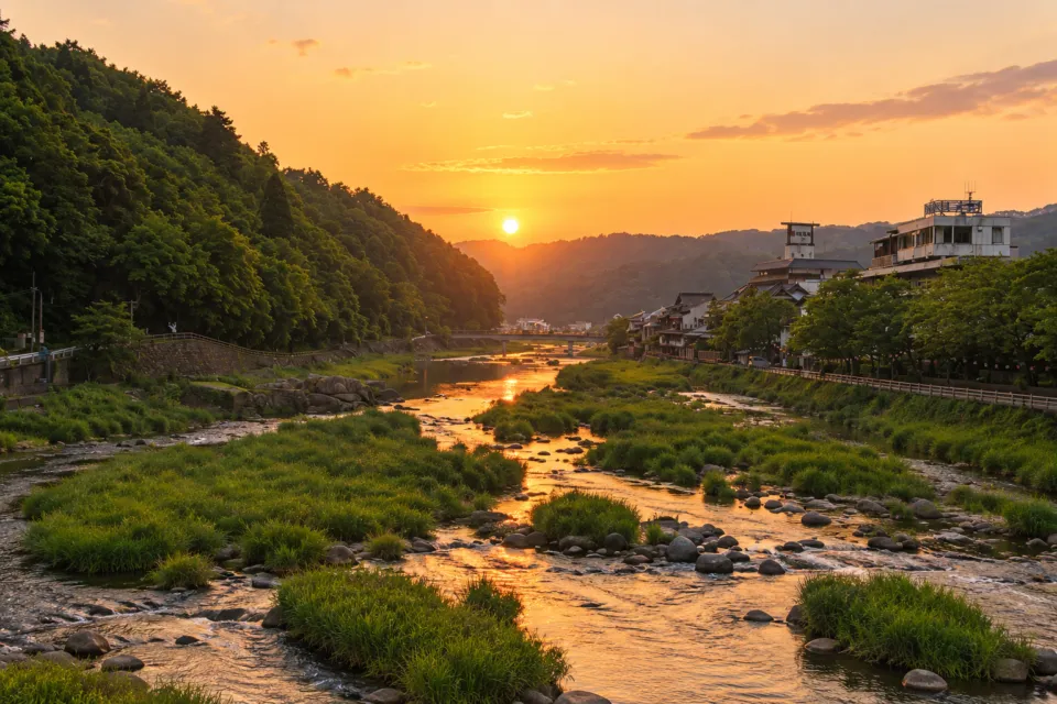 清流荘の夕日を映す三朝川と山並み