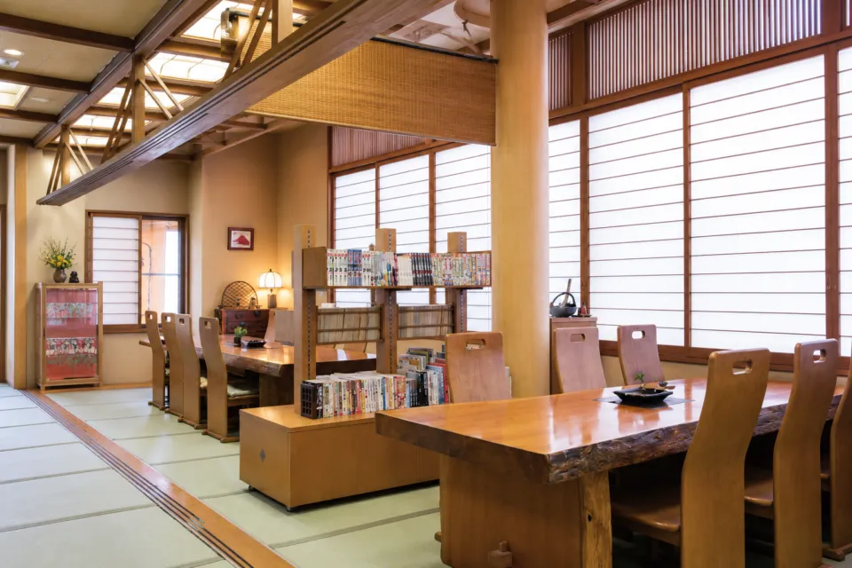 和心の宿 大森の木製テーブルと本棚があるお休み処