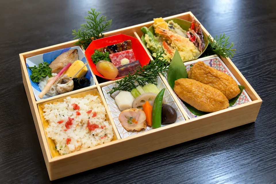 翁 本家の料理を仕切りに盛った弁当
