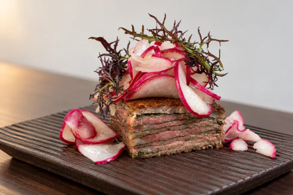 Otto e Sette Oitaの赤い薄切り野菜を添えた肉料理