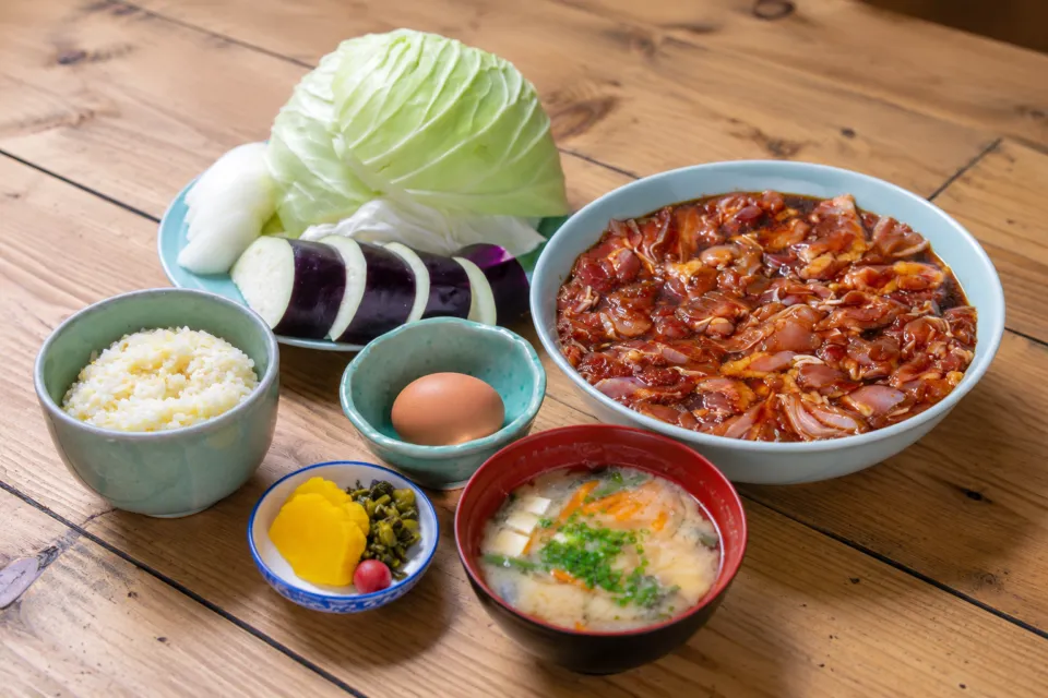 鶏炭火焼 らくだ山の味付け鶏肉と野菜、ご飯や味噌汁が並ぶ定食