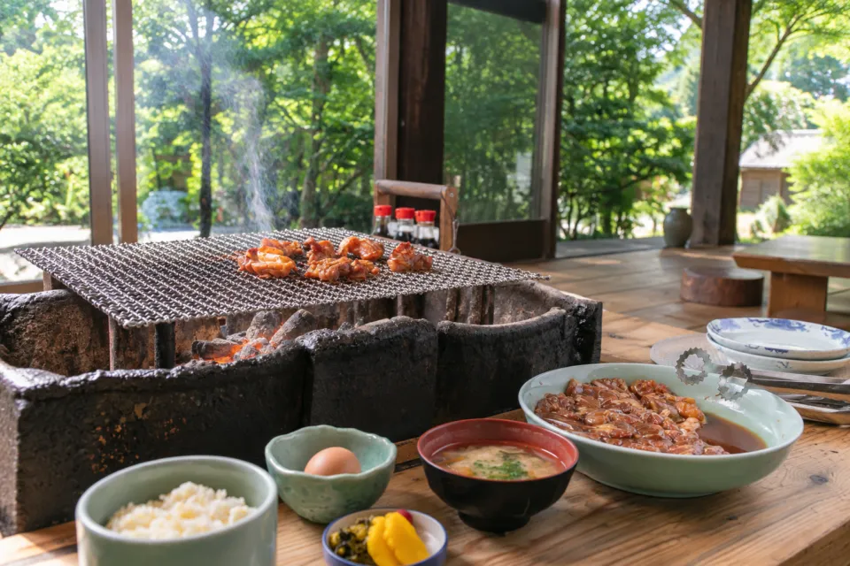 鶏炭火焼 らくだ山の窓際の囲炉裏と炭火焼の定食