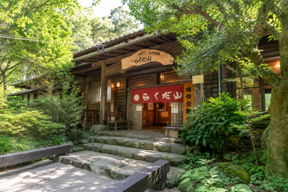 鶏炭火焼 らくだ山の緑に囲まれた木造の店舗入口