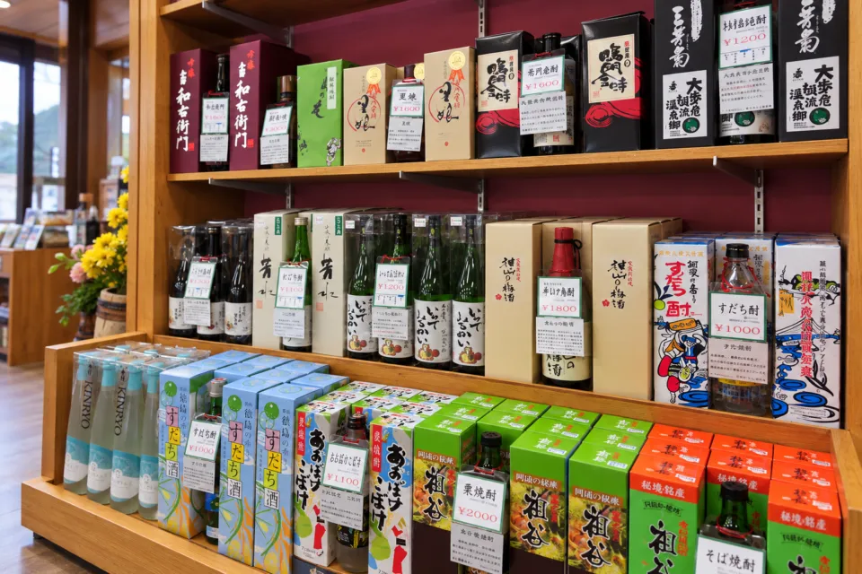レストラン大歩危峡まんなかの地酒の瓶と箱が並ぶ売店棚