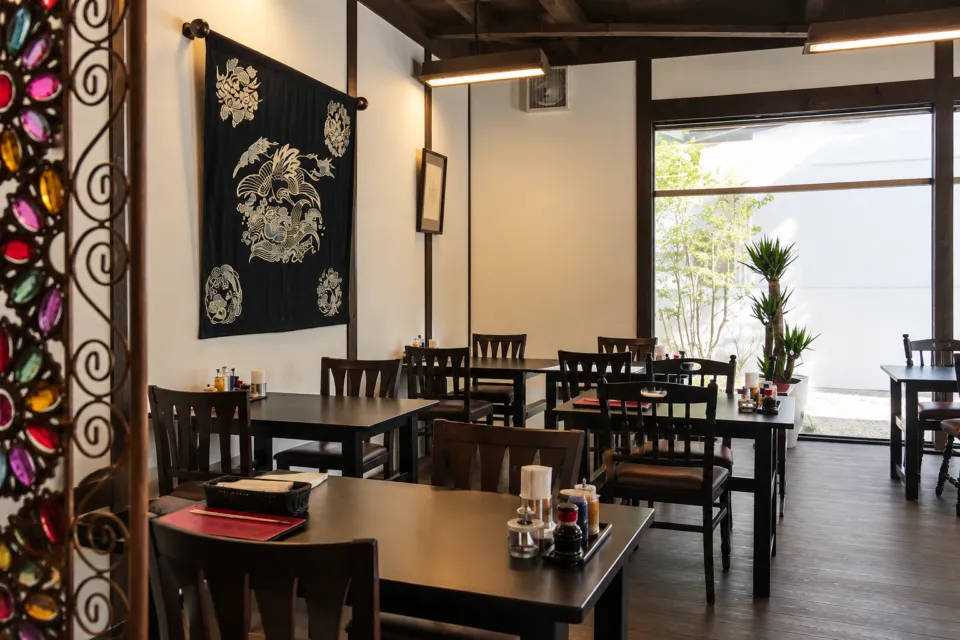 ろんぢん 松江本店ののれんと装飾のあるテーブル席の店内