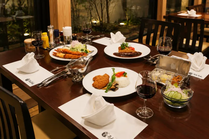 ろんぢん 松江本店の洋食とワイングラスを並べた店内の食卓